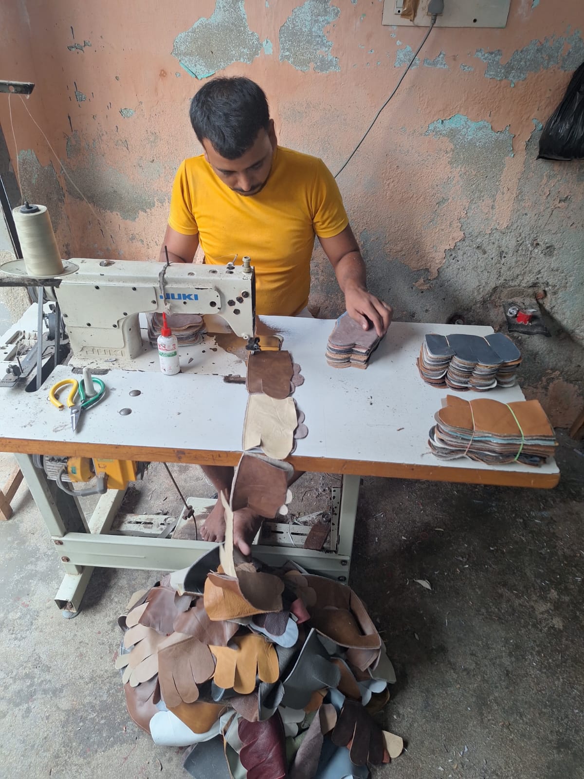 Skilled worker stitching leather panels on a Juki sewing machine