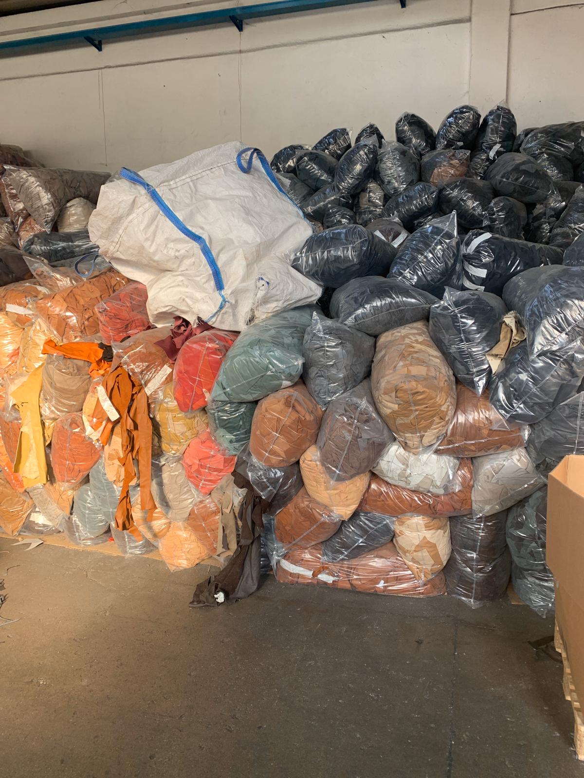 Warehouse floor stacked with bags of finished leather in multiple grades